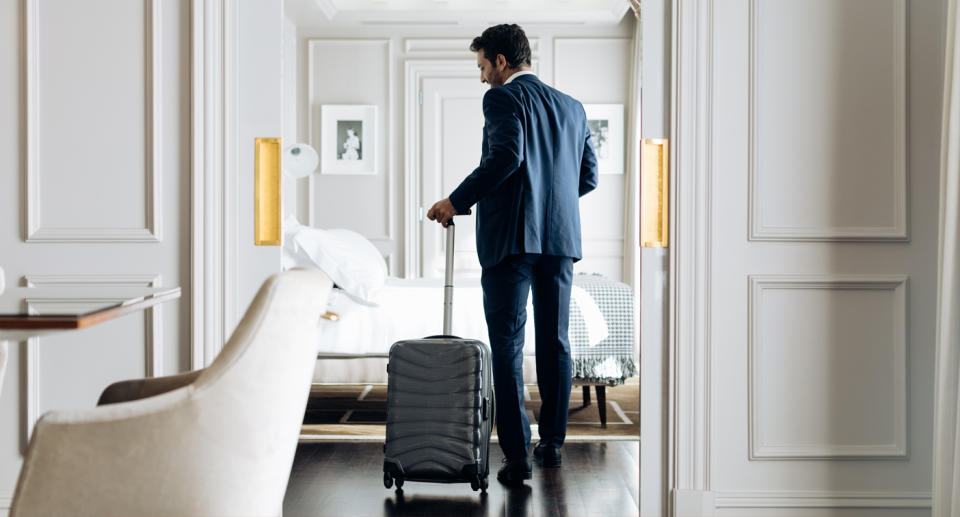 A man walking into a hotel room 