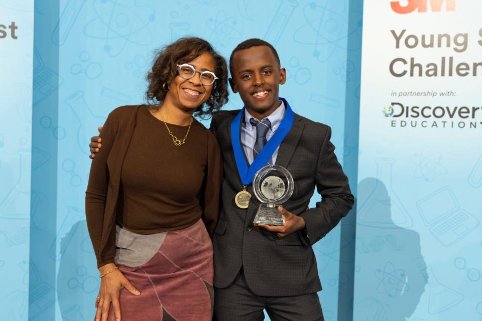 Heman Bekele, 14, is pictured in St. Paul, Minnesota in October 2023 after winning the Young Scientists Challenge for inventing soap to treat melanoma. With him is his mentor, Deborah Isabelle, a product engineering specialist at 3M.