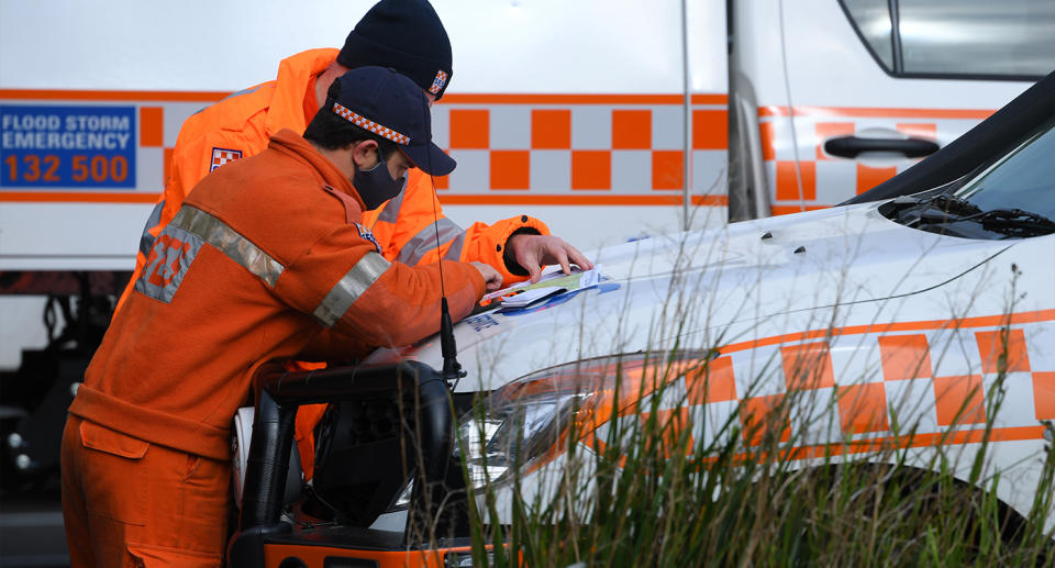 Two SES personnel examine a map before continuing search for William Wall. 