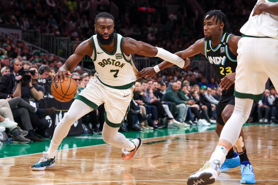 Celtics forward Jaylen Brown drives to the basket defended by Pacers forward Aaron Nesmith.