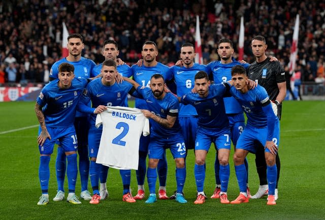 Greece's players hold up a 'Baldock 2' shirt up before kick-off at Wembley