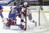 New Jersey Devils' Jack Hughes, right, scores against New York Rangers goalie Alexandar Georgiev during the second period of an NHL hockey game Tuesday, Jan. 19, 2021, in New York. (Bruce Bennett/Pool Photo via AP)