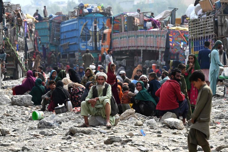 Afghan refugees rest near trucks upon their arrival from Pakistan at the Afghanistan-Pakistan Torkham border in Nangarhar province on November 1, 2023. (AFP via Getty Images)