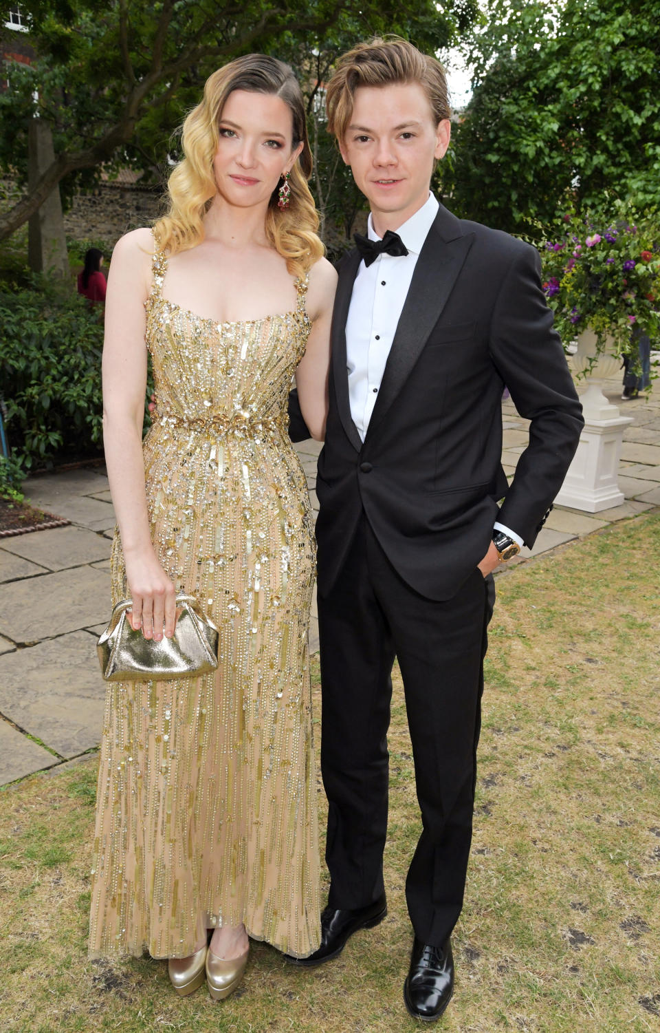 the couple in formal wear posing outside