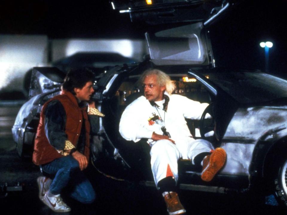 Marty (Michael J. Fox, l. ) und Doc (Christopher Lloyd) mit dem DeLorean in "Zurück in die Zukunft" (1985). (Bild: GLOBE PHOTOS,INC. / ImageCollect)