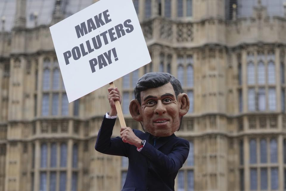 Oxfam's Rishi Sunak 'big head' protests outside the Parliament in London, Tuesday, Sept. 19, 2023. On the eve of the UN Climate Ambition Summit, Oxfam's Rishi Sunak 'big head' staged a protest on top of a giant oil barrel, amongst dozens of real oil drums, supporting the Make Polluters Pay campaign. Calling for oil and gas giants, such as BP and Shell, to pay more tax to raise critical funds to help communities devastated by climate change. (AP Photo/Kin Cheung)