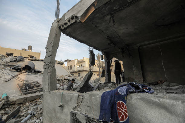 People search through buildings, destroyed during Israeli air strikes in the southern Gaza Strip on 13 November 2023 in Khan Yunis, Gaza (Getty Images)