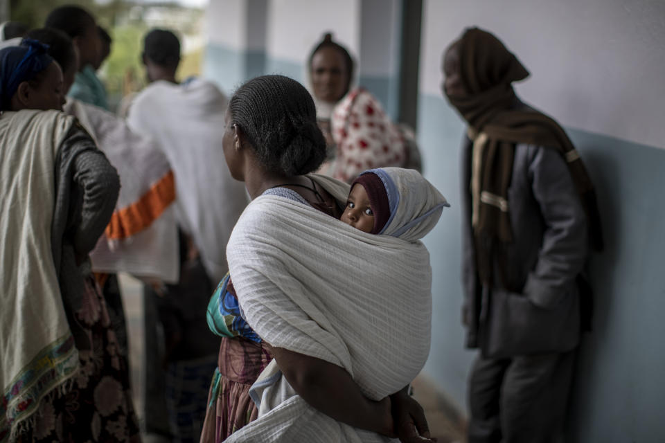 A baby sits on his mother's back as they wait to see a visiting doctor at a hospital which was damaged and looted by Eritrean soldiers who used it as a base, according to witnesses, in Hawzen, in the Tigray region of northern Ethiopia, on Friday, May 7, 2021. The battle for Hawzen is part of a larger war in Tigray between the Ethiopian government and the Tigrayan rebels that has led to the flight of more than 2 million of the region’s 6 million people. (AP Photo/Ben Curtis)