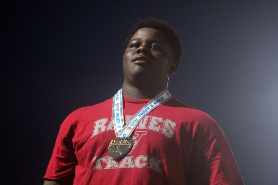 Raines sophomore Solomon Thomas stands atop the podium with his boys discus gold medal.
