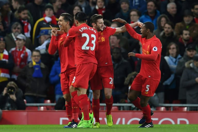 Liverpool's midfielder Roberto Firmino (L) celebrates with teammates after scoring the opening goal of the English Premier League football match against Arsenal March 4, 2017