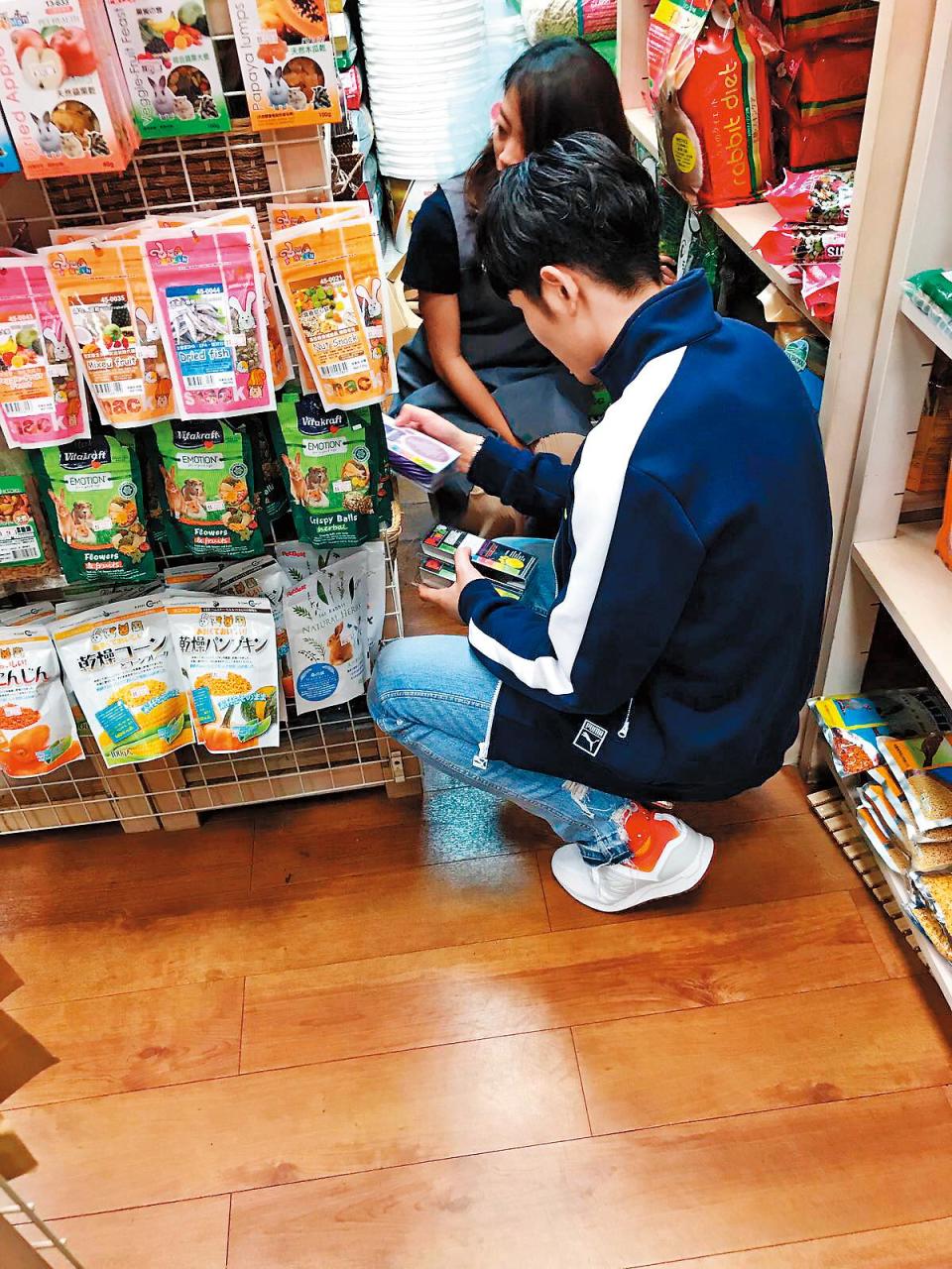 蕭敬騰在寵物店仔細研究毛小孩營養品，然後打包回家。