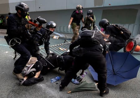 FILE PHOTO: A riot police officer fires pepper-spray projectile toward anti-government protesters demonstrating near the Legislative Council building in Hong Kong