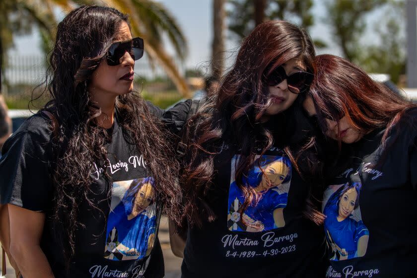 LANCASTER, CA - MAY 13: Lizeth Gaxiola, left, Angela Sanchez, and Vanessa Sandoval grieve at a fundraiser car wash for their sister one of four Mojave shooting victim Martina Barraza held at Sammy's Restaurant, Lancaster, CA. (Irfan Khan / Los Angeles Times)