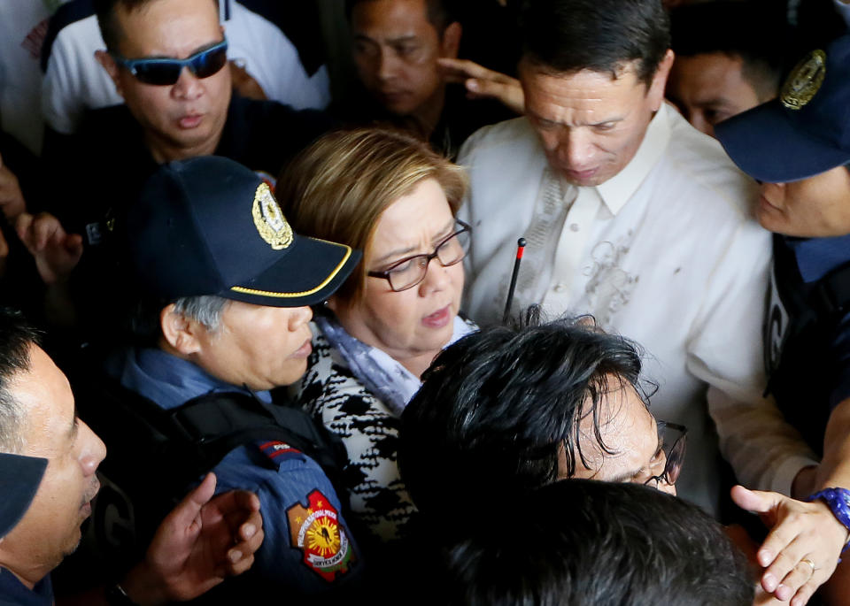 Philippine opposition Sen. Leila de Lima, center, is escorted to her detention a day after a warrant for her arrest was issued by a regional trial court, Friday, Feb. 24, 2017, in suburban Pasay city, south of Manila, Philippines. De Lima was arrested Friday on drug charges but professed her innocence and vowed she would not be intimidated by a leader she called a "serial killer." (AP Photo/Bullit Marquez)