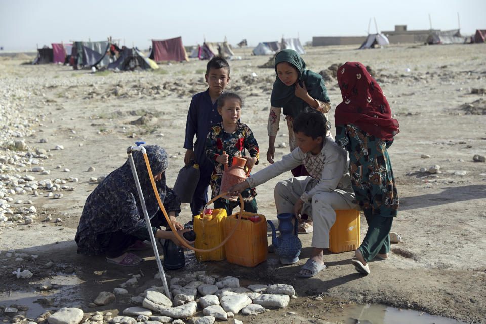 Internally displaced Afghans, who fled their home due to fighting between the Taliban and Afghan security personnel, fill water containers from a public water tap at a camp on the outskirts of Mazar-e-Sharif, northern Afghanistan, Thursday, July 8, 2021. As the Taliban surge through the north of Afghanistan, a traditional stronghold of U.S.-allied warlords and an area dominated by the country’s ethnic minorities, thousands of families are fleeing their homes, fearful of living under the insurgents’ rule. (AP Photo/Rahmat Gul)