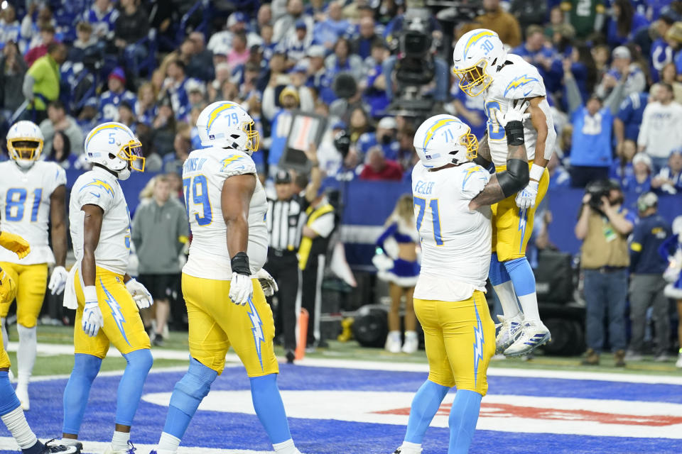 Los Angeles Chargers' Austin Ekeler (30) celebrates running for a touchdown with Matt Feiler (71) during the first half of an NFL football game against the Indianapolis Colts, Monday, Dec. 26, 2022, in Indianapolis. (AP Photo/Michael Conroy)