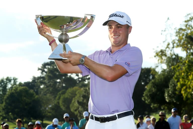 Justin Thomas of the US celebrates with the trophy on the 18th green after winning the FedExCup and second in the TOUR Championship, at East Lake Golf Club in Atlanta, Georgia, on September 24, 2017