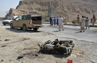 FILE - In this Sept. 5, 2021 file photo, Security officials examine the site of suicide bombing in a checkpoint on the outskirts of Quetta, Pakistan. The Taliban win next door in Afghanistan is good news for Pakistani militants and the country's toxic mix of radical religious parties, but bad news for the government, even as it proposes talks with the violent anti-Pakistan Taliban, say analysts and tribal influencers. (AP Photo/Arshad Butt, File)