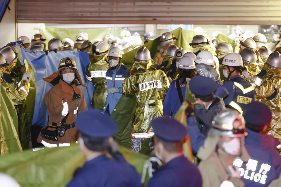 Firefighters gather at a train station in Chofu, a Tokyo suburb, on Oct. 31, 2021, after a fire broke out on a train car. A Japanese court sentenced Kyota Hattori, who was arrested at the scene, to 23 years in prison on Monday, July 31, 2023, for stabbing a passenger and setting a fire on a Tokyo express train while dressed in a Joker costume on Halloween two years ago, officials said. (Kyodo News via AP)