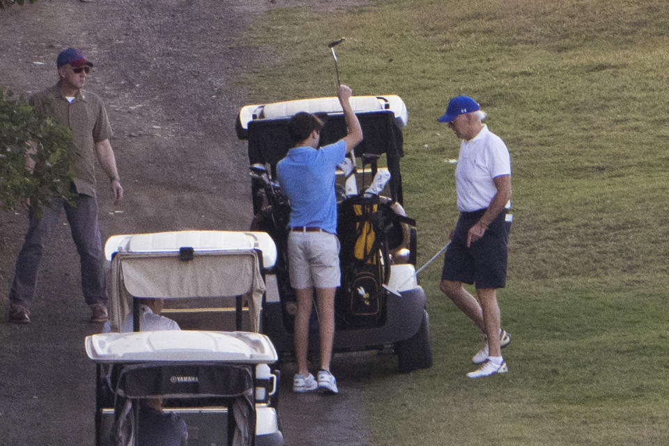 President Joe Biden walks back to his golf cart as he plays golf with grandson Hunter Biden, center, at The Buccaneer in Christiansted, U.S. Virgin Islands, Friday, Dec. 30, 2022. (AP Photo/Manuel Balce Ceneta)