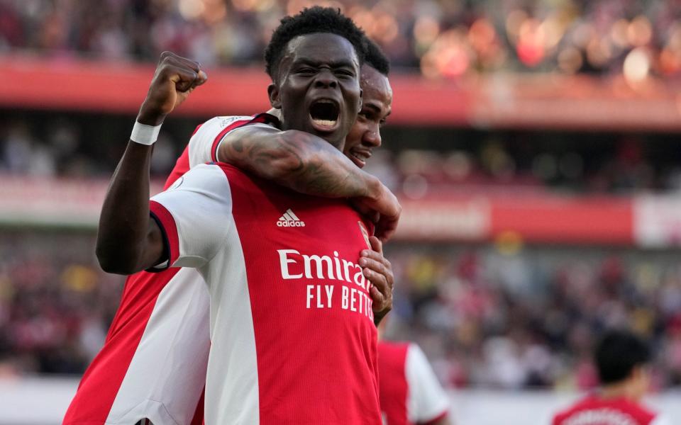 Arsenal's Bukayo Saka, front, celebrates after scoring his side's third goal during the English Premier League soccer match between Arsenal and Tottenham Hotspur at the Emirates stadium in London, Sunday, Sept. 26, 2021.  - AP