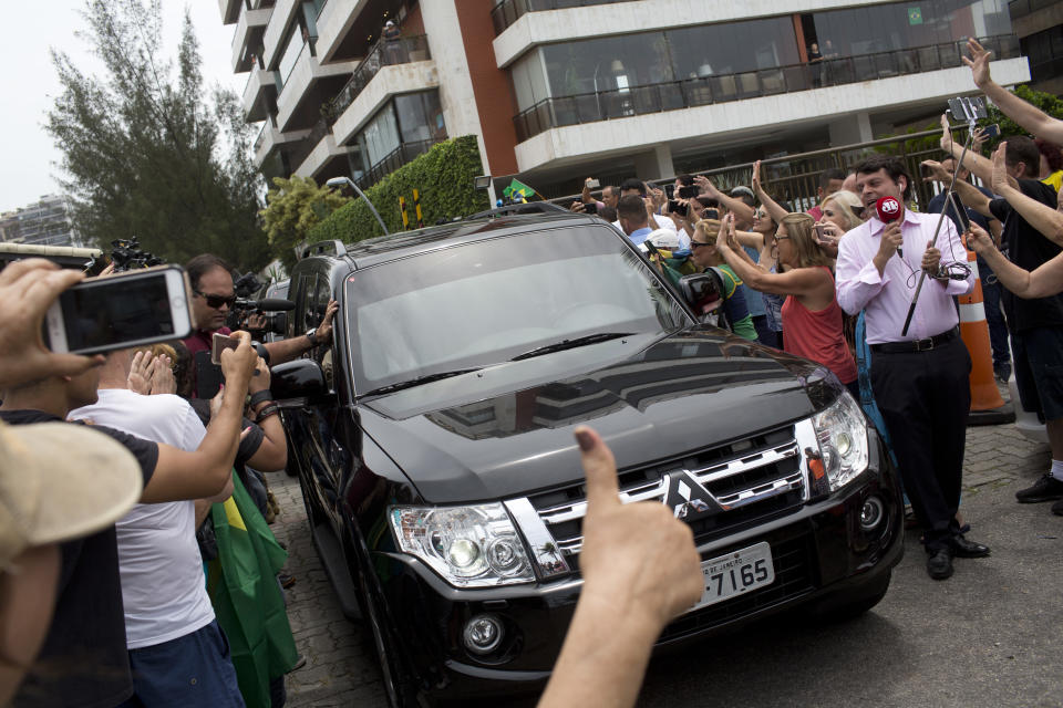 Supporters of President-elect Jair Bolsonaro surround the car carrying Judge Sergio Moro as he leaves Bolsonaro's home following a meeting in Rio de Janeiro, Brazil, Thursday, Nov. 1, 2018. Bolsonaro has said he wants Moro to be justice minister or to fill the next vacancy on the Supreme Federal Tribunal, Brazil's top court. Moro told the AP in a statement earlier this week he was honored and considering the possibilities. (AP Photo/Silvia Izquierdo)