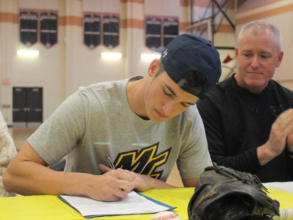 Taunton baseball's Dawson Bryce signs his National Letter of Intent to play for Merrimack College as dad Matt Bryce watches on during a signing ceremony on Nov. 14, 2022.