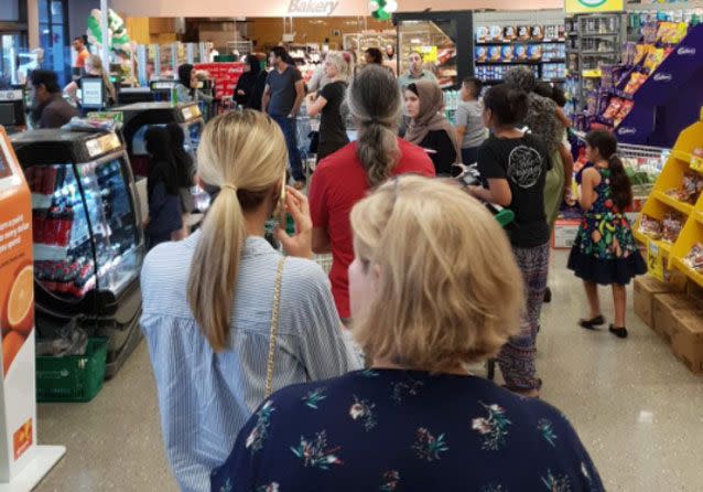 Shoppers line up at a Woolworths store in Sydney following the IT issue. Source: Twitter/ Nazli Aktac