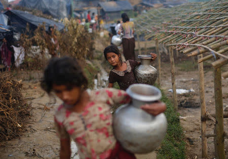Rohingya refugee girls carry metal pitchers with water at Balukhali makeshift refugee camp in Cox's Bazar, Bangladesh, September 13, 2017. REUTERS/Danish Siddiqui