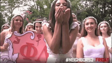 A sorority girl blows glitter into the camera