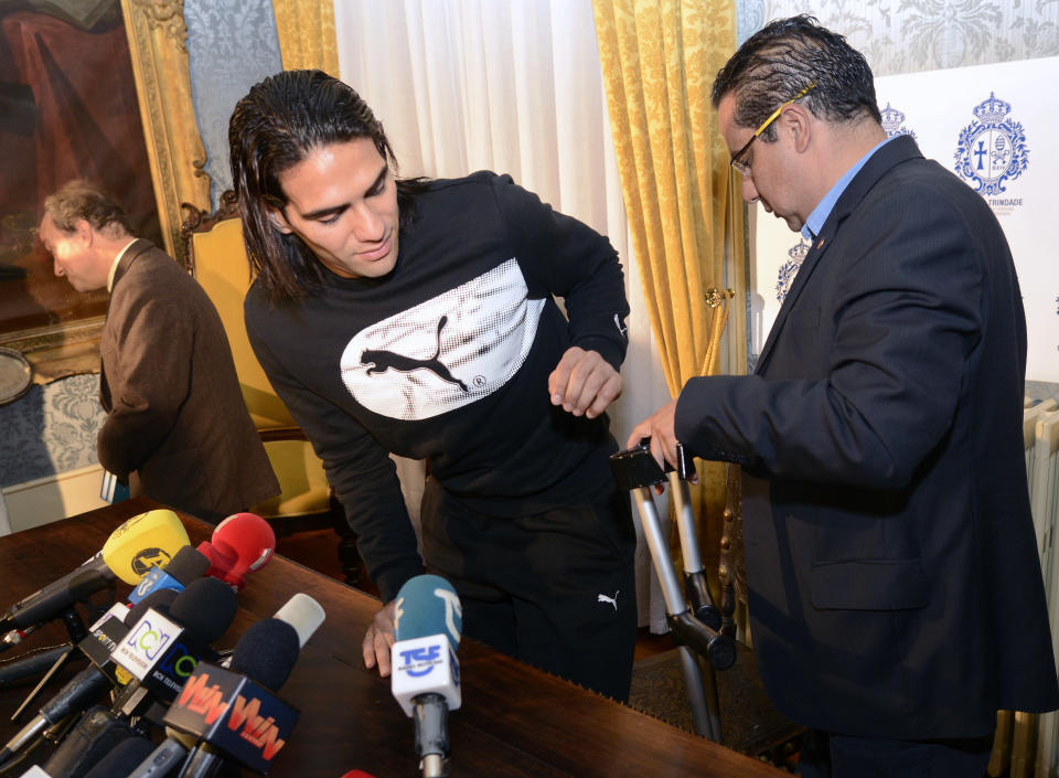 Colombian soccer star Radamel Falcao is helped with his crutches by Doctor Carlos Ulloa, right, also from Colombia after a press conference at the Trindade Hospital in Porto, Portugal, Monday, Jan. 27, 2014. Colombia and Monaco's striker Falcao is in a race against time to get fit for the World Cup in June after undergoing knee surgery Saturday, Jan. 25, with his doctor giving him a better than 50-50 chance of making it. (AP Photo/Paulo Duarte)