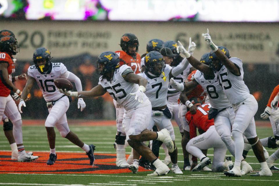 West Virginia defensive lineman Dante Stills (55) celebrates after recovering a fumble during the second half of the NCAA college football game against Oklahoma State in Stillwater, Okla., Saturday Nov. 26, 2022. (AP Photo/Mitch Alcala)