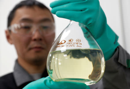 An employee holds a bulb with diesel at the laboratory of an oil and gas treatment plant in the Yarakta Oil Field, owned by Irkutsk Oil Company (INK), in Irkutsk Region, Russia March 10, 2019. REUTERS/Vasily Fedosenko