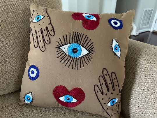 A decorative pillow cover made by Afghan refugees