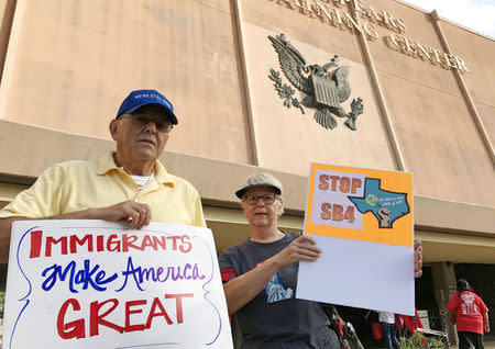 FILE PHOTO: Protesters against the Texas state law to punish "sanctuary cities" stands outside the U.S. Federal court in San Antonio, Texas, U.S., June 26, 2017. REUTERS/Jon Herskovitz/File Photo