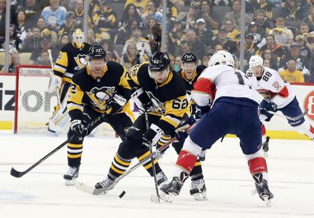 Oct 14, 2017; Pittsburgh, PA, USA; Pittsburgh Penguins left wing Carl Hagelin (62) moves the puck alongside right wing Phil Kessel (81) as Florida Panthers defenseman Mark Pysyk (13) defends during the third period at PPG PAINTS Arena. The Penguins won 4-3. Mandatory Credit: Charles LeClaire-USA TODAY Sports