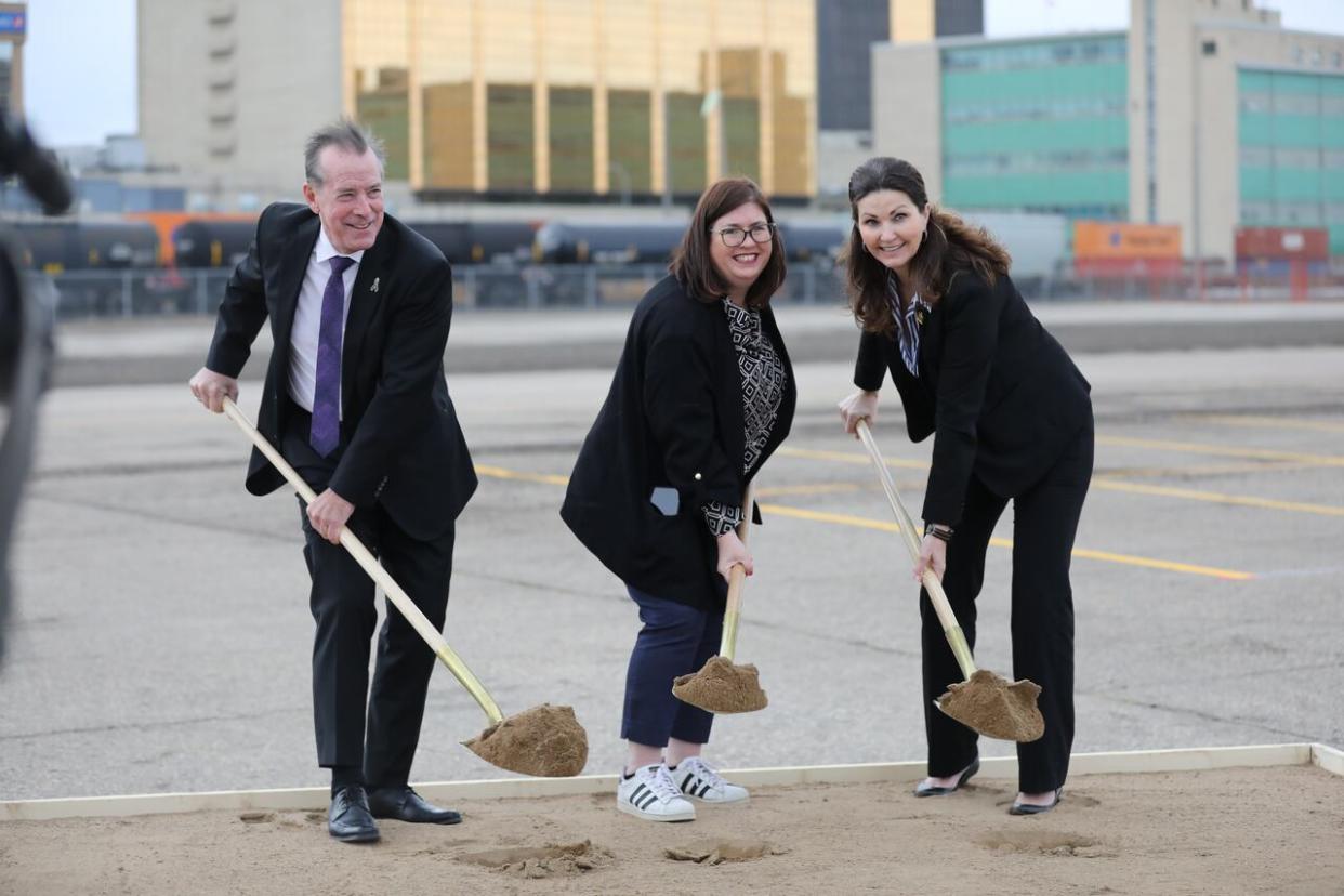 Saskatchewan's Minister of Government Relations Don McMorris, left, executive director of Regina's Warehouse Business Improvement District Leasa Gibbon, centre, and Regina Mayor Sandra Masters take part in a groundbreaking ceremony on April 25, 2024. (Alexander Quon/CBC - image credit)