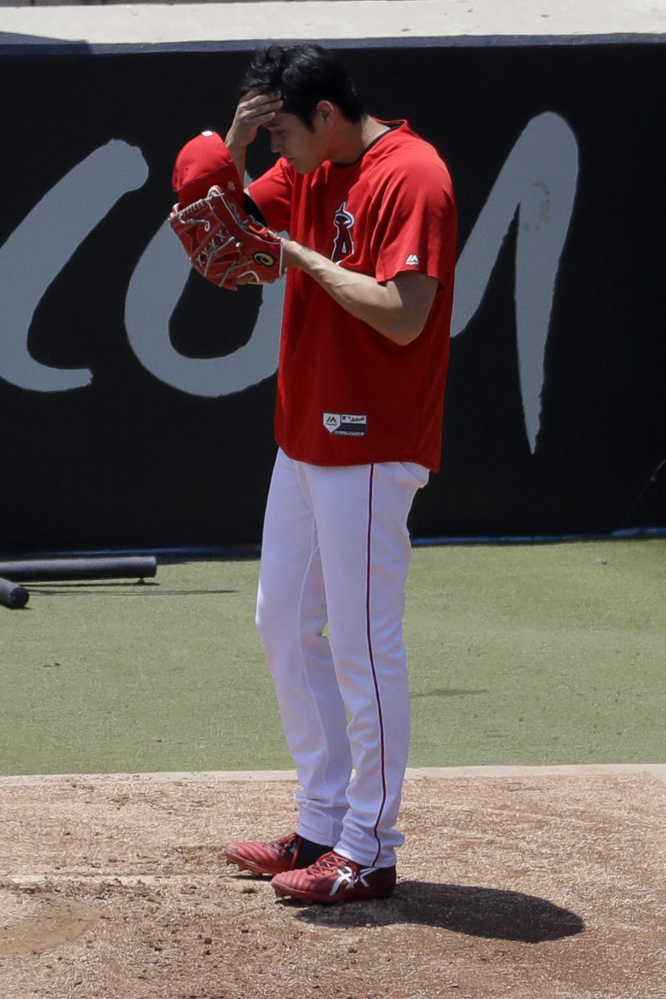 Los Angeles Angels' Shohei Ohtani wipes his face after throwing in the bullpen before a baseball game against the Cincinnati Reds in Anaheim, Calif., Wednesday, June 26, 2019. Ohtani threw off a mound for the first time since Tommy John surgery Oct 1, 2018. (AP Photo/Chris Carlson)