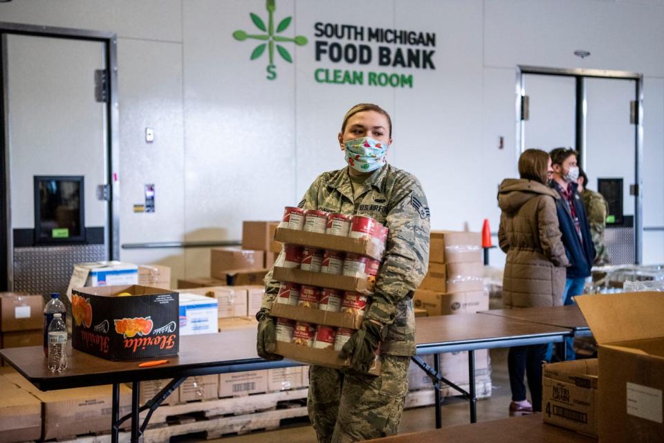 U.S. Air Force National Guard solider Eran Mikolowski packages food at South Michigan Food Bank in Battle Creek, Mich. on Tuesday, April 21, 2020 as unemployment numbers soar to record highs throughout the COVID-19 pandemic.