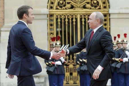 French President Emmanuel Macron (L) welcomes Russian President Vladimir Putin during a meeting in Versailles, France, May 29, 2017. REUTERS/Alexander Zemlianichenko/Pool