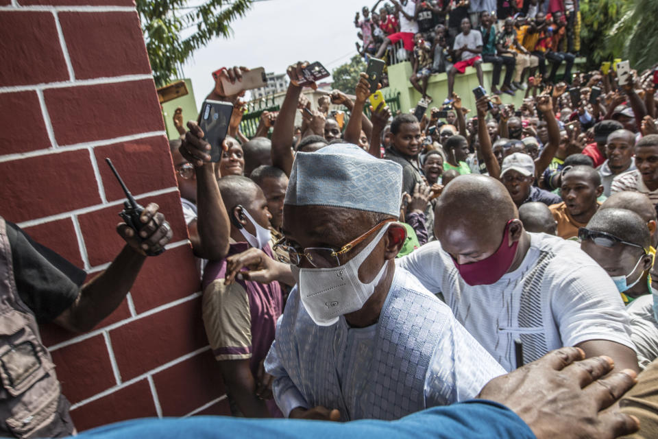 Guinean opposition leader Cellou Dalein Diallo walks past supporters at his headquarters in Conakry, Guinea, Monday Oct. 19, 2020. Diallo declared himself the winner after the country held an election on Sunday with Guinean President Alpha Conde seeking to extend his decade in power. (AP Photo/Sadak Souici)