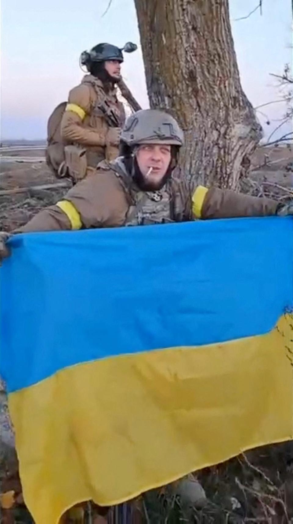 Ukrainians in Kherson have been waving their flag since Russian troops fled (via REUTERS)