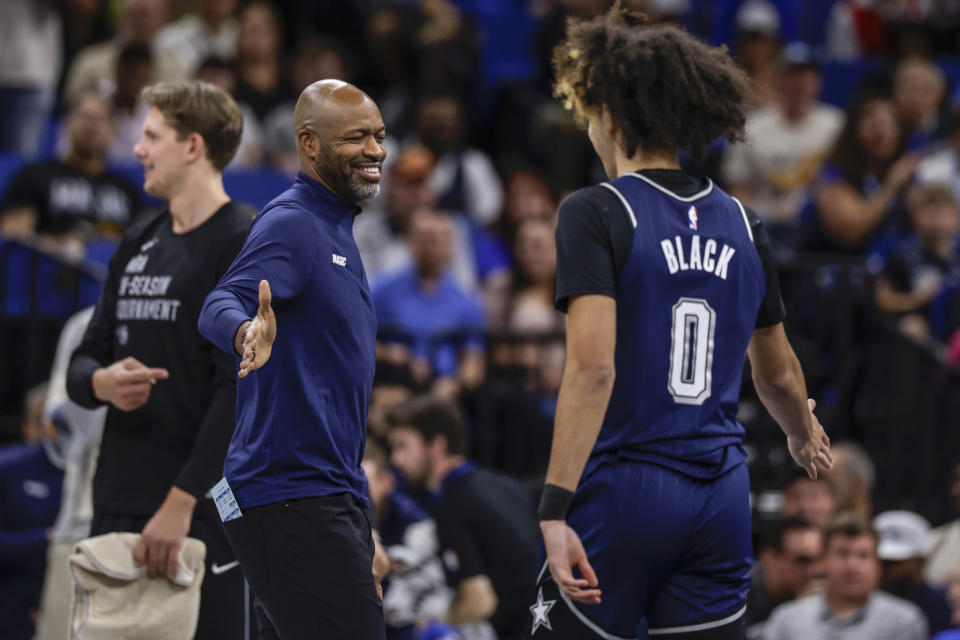 Orlando Magic head coach Jamahl Mosley, left, congratulates guard Anthony Black (0) during the first half of the team's NBA basketball In-Season Tournament game against the Toronto Raptors, Tuesday, Nov. 21, 2023, in Orlando, Fla. (AP Photo/Kevin Kolczynski)