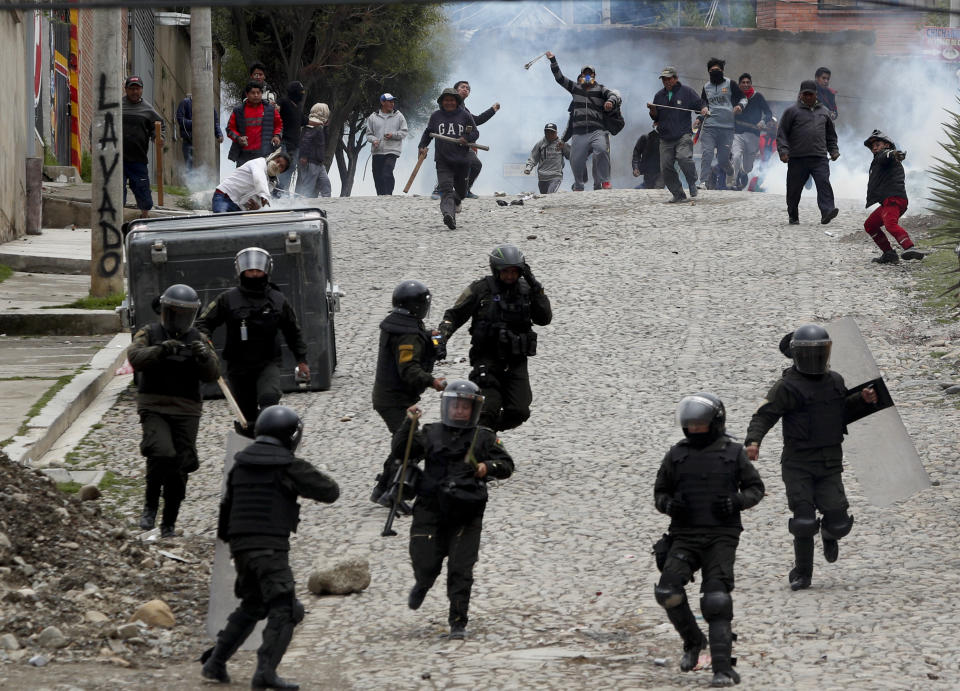 Supporters of former President Evo Morales clash with police in La Paz, Bolivia, Monday, Nov. 11, 2019. Morales' Nov. 10 resignation, under mounting pressure from the military and the public after his re-election victory triggered weeks of fraud allegations and deadly demonstrations, leaves a power vacuum and a country torn by protests against and for his government. (AP Photo/Juan Karita)