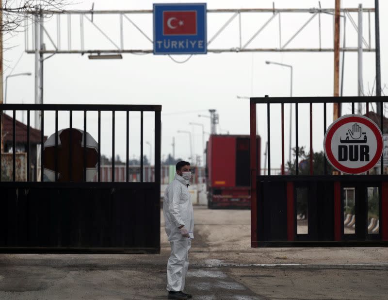 Health worker stands at the Bab el-Salam border crossing between the Syrian town of Azaz and the Turkish town of Kilis