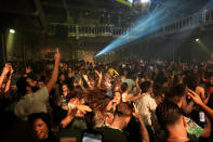 People dance in close proximity at Paradiso pop venue, club and cultural center, in Amsterdam, Saturday, Sept. 25, 2021, the day The Netherlands dropped the coronavirus related 1.5 meter (5 feet) rule. Paradiso is housed in a converted former church building that dates from the nineteenth century. (AP Photo/Peter Dejong)