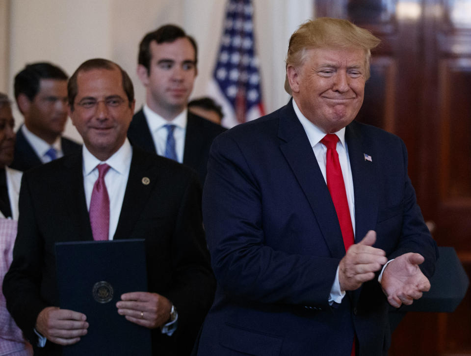 In this June 24, 2019 photo, President Donald Trump, joined by Secretary of Health and Human Services Alex Azar, left, applaudes after signing an executive order on improving price and quality transparency in healthcare at the White House in Washington. (AP Photo/Carolyn Kaster)