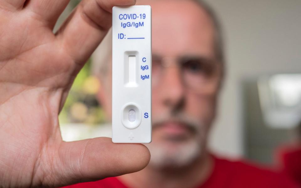 A man holding a Covid-19 test - iStockphoto