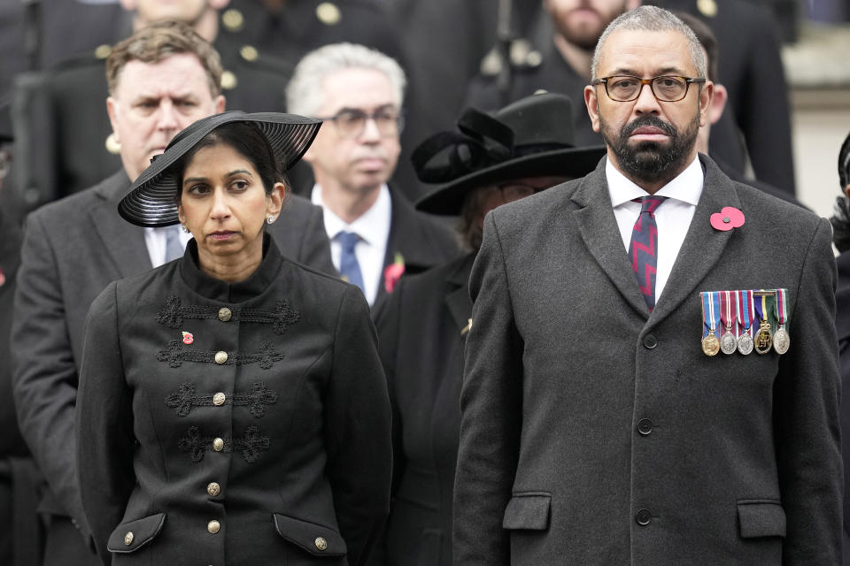 FILE - Britain's Home Secretary Suella Braverman stands with Foreign Secretary James Cleverly as they attend the Remembrance Sunday service at the Cenotaph on Whitehall in London, Sunday, Nov. 12, 2023. The government said on Monday, Nov. 13, 2023, Braverman had left her job as part of a Cabinet shuffle as Prime Minister Rishi Sunak shakes up his top government team. She was replaced by James Cleverly, who had been foreign secretary. (AP Photo/Kin Cheung, Pool, File)