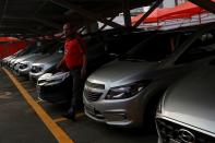 A man walks past some cars at the car park of a newly opened Movida car rental service store specialized in ride-hailing companies in Sao Caetano do Sul